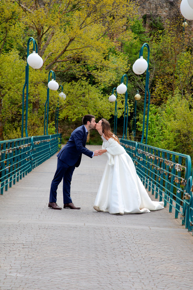 novia y novio dandose un beso en el puente de los candados de el río Duero reportaje de boda de Alvaro Rodriguez